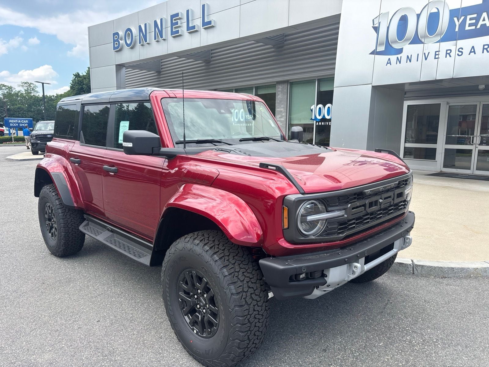 2026 Ford Bronco Raptor in Ruby Red Metallic Tinted Clearcoat — front three-quarter view